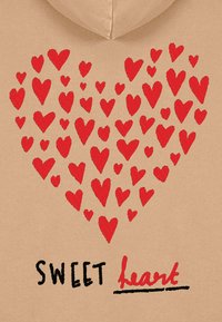 Sudadera beige con un diseño de corazón formado por varios corazones bordados en rojo, con el texto "SWEET heart" en negro y rojo debajo.