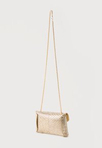Bolso clutch metálico dorado con patrón de cuentas en forma de chevron y correa delgada de cadena colgando sobre fondo blanco.