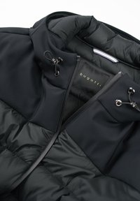 Schwarze Pufferjacke mit glatter Oberfläche und gestepptem Futter. Sie verfügt über einen hohen Kragen, einen Reißverschluss und Kordeln zur Anpassung.