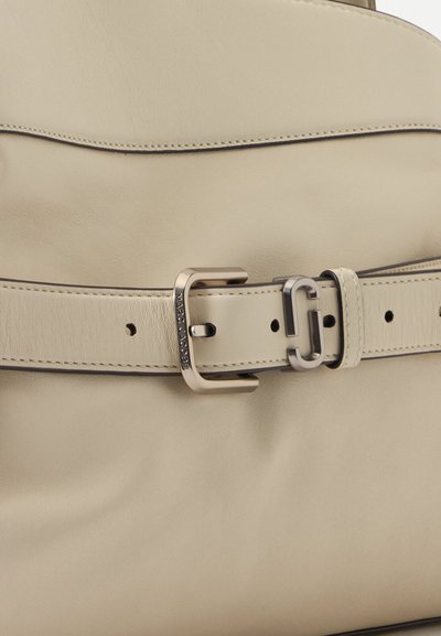 Ceinture en cuir beige avec boucle argentée et passant, couture détaillée et nom de marque embossé sur la boucle.
