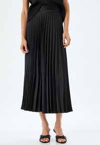 Falda midi plisada negra hecha de material brillante con una cintura ceñida. Presenta pliegues verticales marcados y un diseño fluido.