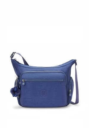 Blue shoulder bag made of fabric. Features a zippered front pocket, adjustable strap, and a furry keychain accessory. Textured surface.