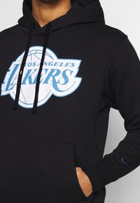 Czarna bluza z kapturem z dużym białym i jasnoniebieskim logo "Los Angeles Lakers", kieszenią kangurzą i niebieskim znakiem Nike na rękawie.