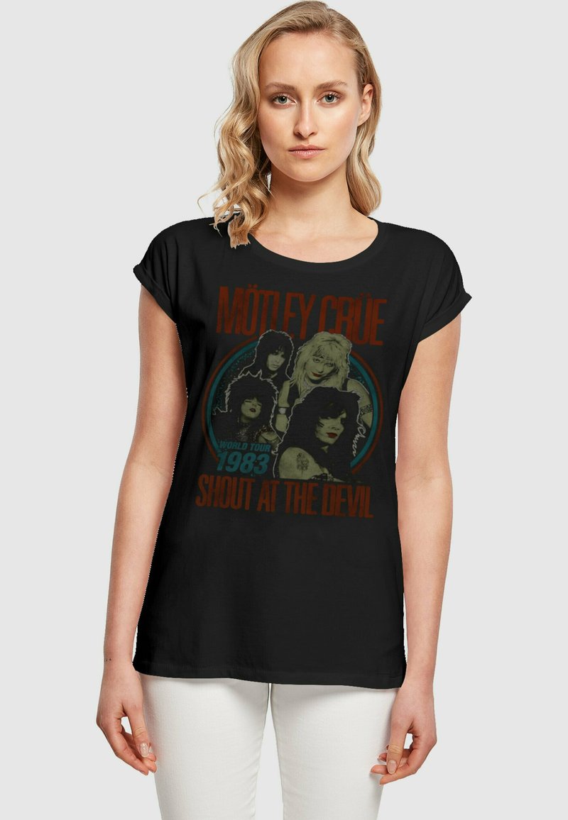 Svart t-skjorte med Mötley Crüe grafikk, vintage design og fargerike detaljer med teksten "Shout at the Devil" og "World Tour 1983".