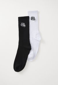 Calzini in misto cotone nero e bianco. Ogni calzino ha una texture a costine e presenta un logo ricamato vicino alla parte superiore.