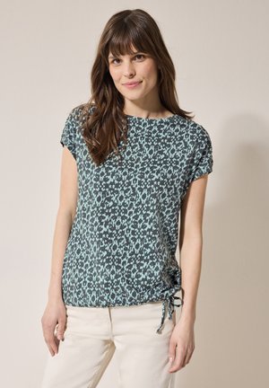 T-shirt à manches courtes en vert foncé avec un motif abstrait turquoise clair, présentant un col rond et des liens ajustables à l'ourlet.