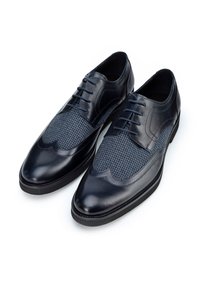 Scarpe in pelle blu navy con superiore texturizzato che presenta un motivo a pied de poule, punta affusolata e design decorativo a wingtip.
