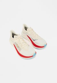 Αθλητικά παπούτσια Hoka Rocket X 3 με επάνω μέρος σε κρεμ απόχρωση, κόκκινα σημεία στη σόλα, γαλάζιο μπροστινό μέρος και εμφανές λογότυπο στο πλάι. Μαλακό, αναπαυτικό σχέδιο.