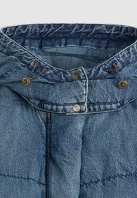Jeansjack met een hoge kraag, voorzien van bronzen drukknoopjes en een trekkoord. De stof heeft een gestructureerde, licht vervaagde blauwe afwerking.