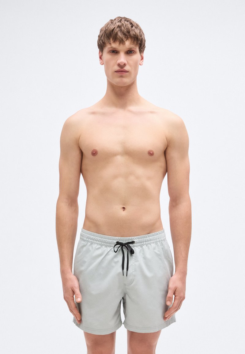 Ανοιχτό γκρι μαγιό βερμούδα με ελαστική μέση και μαύρο κορδόνι, κοντό μήκος, με λεία υφή και χωρίς ορατά σχέδια.