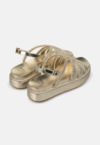 Gold platform sandals with braided metallic straps and an adjustable buckle. Textured footbed and smooth sole enhance comfort and stability.