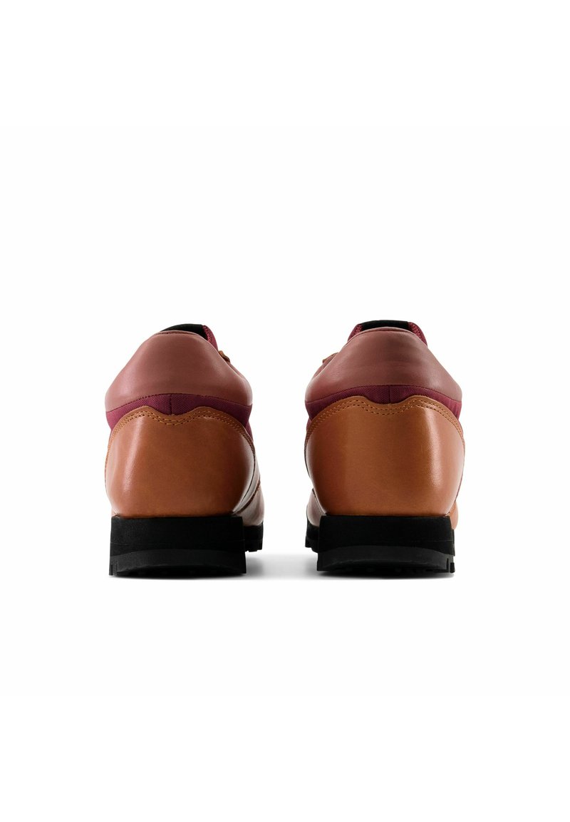 Chaussures en cuir marron avec des accents bordeaux, talons ronds, surfaces texturées et semelles en caoutchouc noir. Vue de l'arrière.