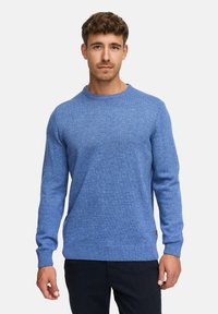 Niebieski sweter dzianinowy z okrągłym dekoltem, długimi rękawami oraz ściągaczami przy mankietach i u dołu. Tkanina wydaje się miękka i ma teksturowane wykończenie.