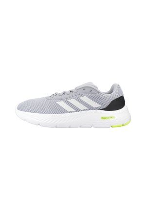 Zapatilla deportiva de malla gris claro con suela blanca, rayas blancas de Adidas en el lateral, acento negro en el talón y pequeña etiqueta amarilla "Cloudfoam Walk" en la suela.