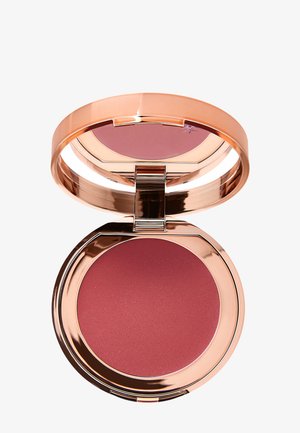 Compact de blush rond avec un extérieur réfléchissant en or rose, révélant une poudre de couleur rose profond à l'intérieur. Texture lisse, fermeture magnétique.