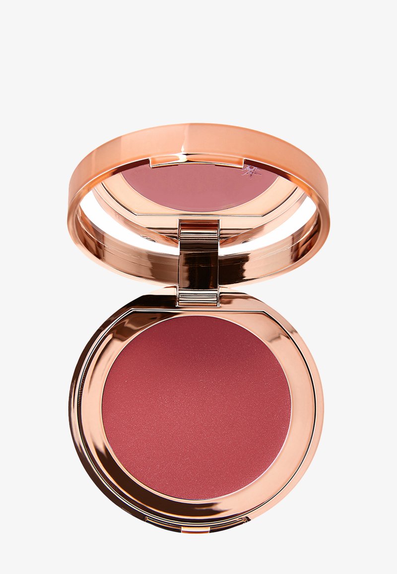 Round blush compact with a reflective rose gold exterior, revealing a deep rose-colored powder inside. Smooth texture, magnetic closure.