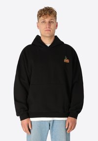 Zwarte hoodie met een voorzak, voorzien van een klein geborduurd ontwerp in rood en groen op de bovenste linkerzijde. Katoenmix stof.