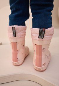 Stivali di gomma rosa con polsini imbottiti trapuntati e morbidi, decorati con stampe di fate, finitura liscia e tacco solido rosa.