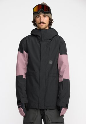 Veste de snowboard noire et rose avec capuche, présentant un design épuré, des poignets réglables et des poches. Accompagnée de gants et de lunettes.
