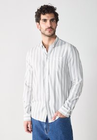 Lange mouw knoopsluiting shirt in lichtgrijs met witte verticale strepen, voorzien van een borstzak en een zachte stoftextuur.