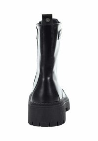 Czarne skórzane botki sięgające kostki z wytrzymałą, teksturowaną podeszwą, kontrastowym matowym i błyszczącym wykończeniem, z pętelką do zakupu i małym detalem logo.