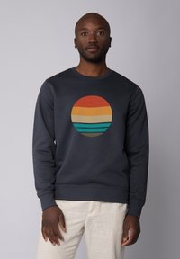 Marine sweatshirt met een ronde graphic met horizontale strepen in oranje, geel, beige en teal. Geribbelde manchetten en kraag.