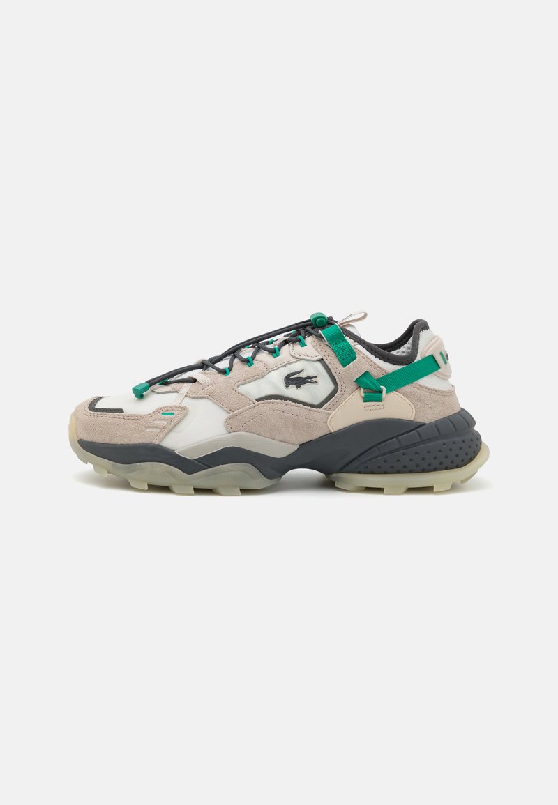 Lacoste sneakers with a beige upper, black accents, and green laces. Features padded collar and textured sole for traction.