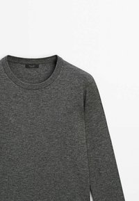 Szary sweter z długim rękawem i okrągłym dekoltem, wykonany z miękkiej, teksturowanej tkaniny. Charakteryzuje się minimalistycznymi szwami i metką wewnątrz kołnierza.