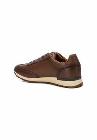 Zapatilla de cuero marrón con textura suave, punta redonda, diseño con cordones, mediado beige y sutiles detalles de costura. Suela de goma plana.