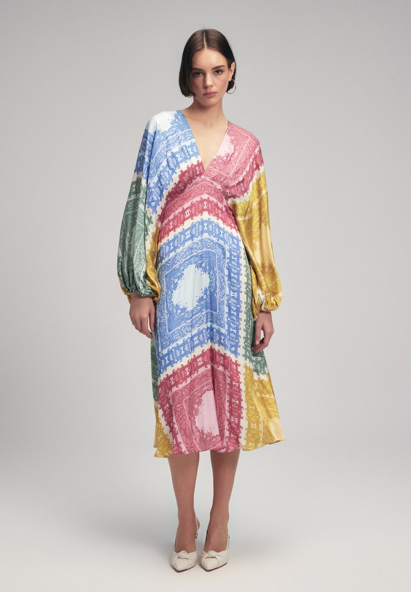 Vestido de manga larga que presenta un audaz patrón de paisley multicolor en rojo, azul, verde y amarillo. Hecho de una tela suave con escote en forma de V.