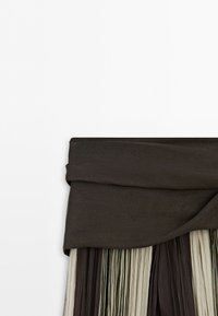 Black waistband skirt with alternating vertical pleats in dark brown, beige, and olive green fabric on a white background.