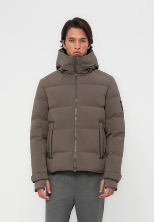 Chaqueta acolchada en un tono marrón apagado, con cuello alto, cierre de cremallera, bolsillos laterales y puños de canalé. La tela parece suave y duradera.