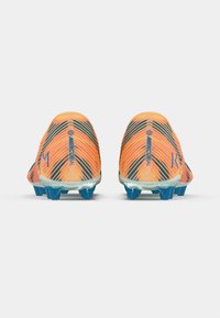 Nike Mercurial futbolu apavi oranžā krāsā ar melniem diagonāliem svītrainiem. Tam ir teksturēts apdare un zilas gumijas tapas nodrošinot saķeri.