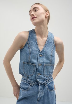 Gilet di jeans blu chiaro, con scollatura a V profonda, tre bottoni e due tasche anteriori. Tessuto texture con dettagli di cucitura.