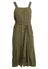 Abito senza maniche verde oliva con spalline regolabili, chiusura frontale con bottoni, tasche applicate, cintura annodata in vita e un tessuto fluido e testurizzato.