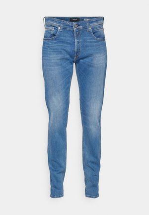 Vaqueros de mezclilla azul con un ajuste slim, diseño de cinco bolsillos, cierre de botón, detalles de lavado ligero y acentos de costura sutiles.