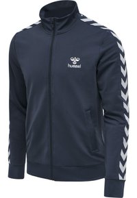 Navyblauwe zip-up jas van zacht materiaal, met een hoge kraag, zijzakken en witte chevronstrepen op de mouwen. Hummel-logo weergegeven.