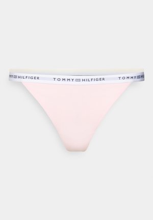 Chilot tip tanga roz, cu o talie elastică albă pe care este inscripționat logo-ul "TOMMY HILFIGER" negru, material neted, design cu acoperire minimă.