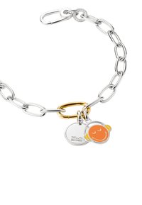 Silberarmband mit großen Gliedern, einem goldenen ovalen Glied und zwei Anhängern: einer mit einem Smiley-Gesicht und der andere mit einem eingravierten Logo.
