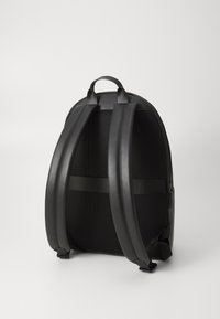 Zaino nero in pelle liscia e tessuto a rete. Forma strutturata con spallacci imbottiti e maniglia superiore. Chiusura a zip sul lato.