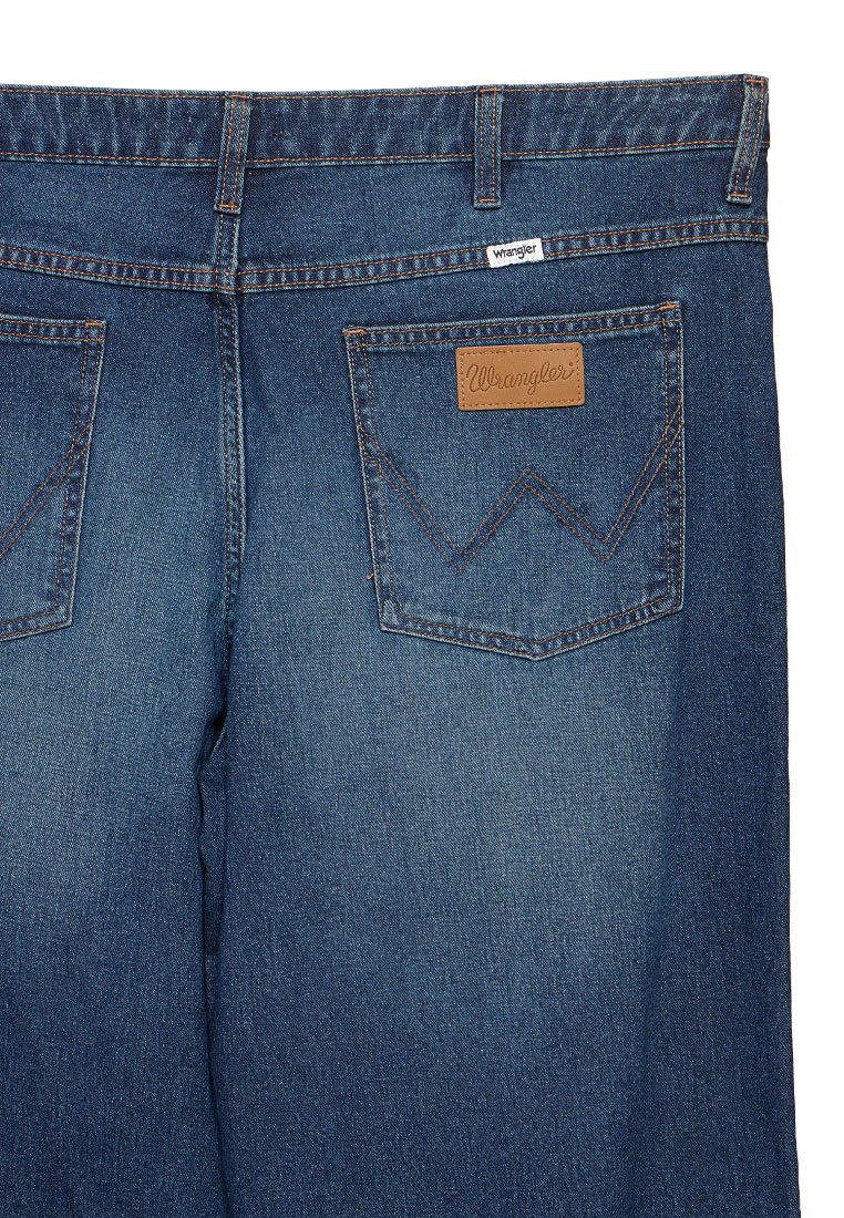 Granatowe dżinsy z wysokim stanem, z dwiema tylnymi kieszeniami zdobionymi wyraźnym przeszyciem oraz skórzaną naszywką z logo "Wrangler."