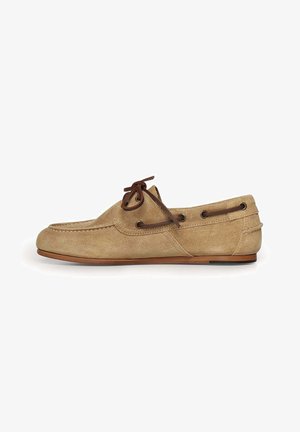Chaussure mocassin en daim beige avec des lacets en cuir marron foncé et une semelle plate marron, vue de côté sur fond blanc.