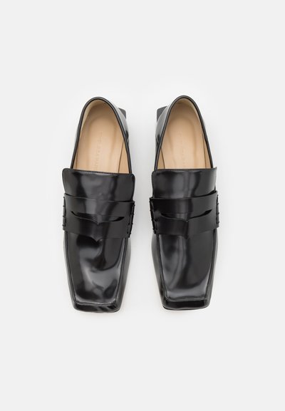 Melnas lakotu ādas loaferi ar kvadrātveida purngalu, ar priekšējo siksniņu, kas rotāta ar smalku reljefu un gludu, spīdīgu virsmu.