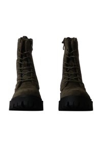 Paire de bottes en daim vert foncé à lacets avec de grosses semelles en caoutchouc noir, vues de face sur un fond blanc.