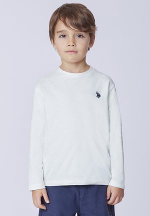 Maglietta bianca a maniche lunghe in cotone con scollatura rotonda e un piccolo logo blu navy sul petto, abbinata a pantaloni in pile blu navy.