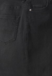 Svarte denimbukser med en enkelt baklomme med spiss klaff, naglelukking og en glatt tekstur.