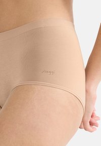 Beige korkeavyötäröiset alushousut, jotka on valmistettu pehmeästä kankaasta. Ne ovat sileäpintaiset ja niissä on hienovarainen logotyyppitys sivussa.