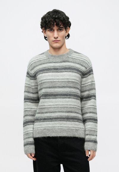 Sivi i bijeli prugasti džemper s okruglim izrezom, izrađen od mekanog, rastezljivog materijala; dugi rukavi sa nešto opuštenijim pristajanjem.