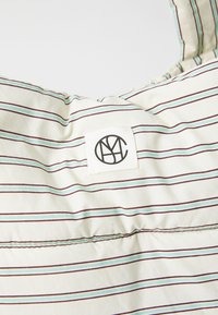Striped fabric bag with light cream background, featuring narrow turquoise and maroon stripes. Includes a rectangular fabric tag with logo.