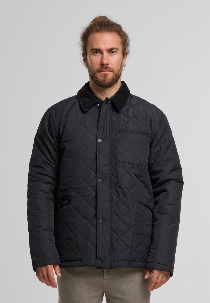 Czarna pikowana kurtka z kołnierzem z kordurowego materiału, z przodem zapinanym na zatrzaski i bocznymi kieszeniami. Posiada wzór w romby oraz kieszeń naszywaną na klatce piersiowej.